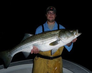 Pat Vogt with a 30-pound striped bass taken casting along the shore aboard Reel Cast Charters.
