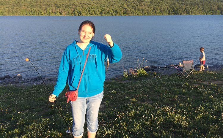 Samantha Steinback, triumphantly displays her First Fish, a bluegill