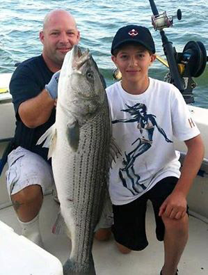 The Avallone boys with a great bass aboard Rock and Roll Charters