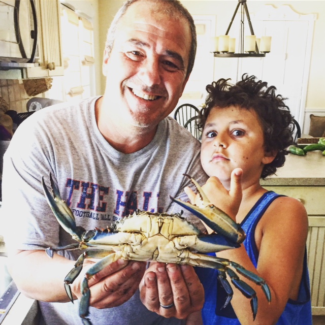Michael Deusch and his son, Charlie, with a nice blue claw plucked from the Shrewsbury River.