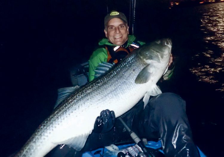 Eric Harrison with a large striper caught in a pedal kayak.