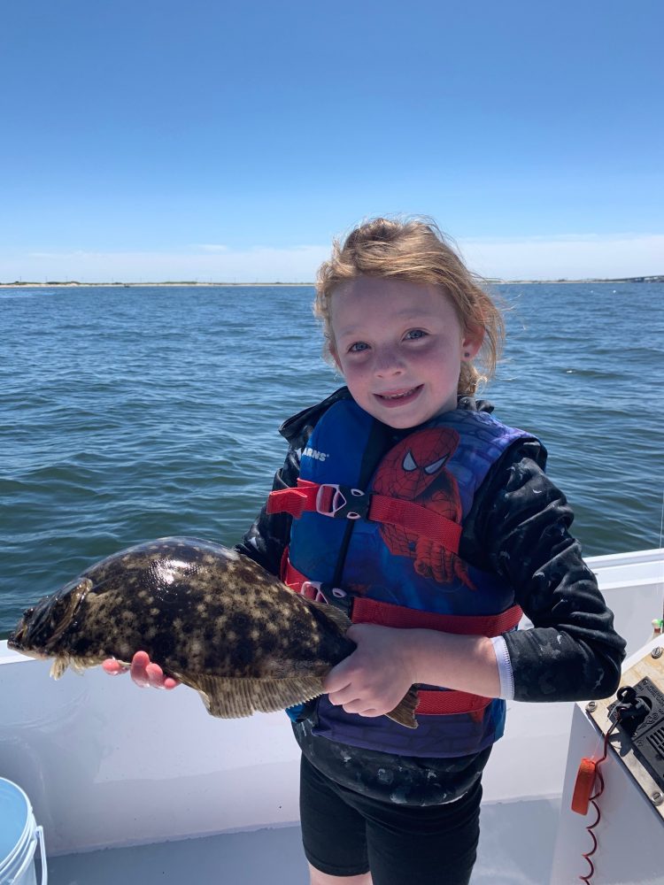 7-year-old Julia Moore holding a fluke that was caught in Sandy Hook Bay, New Jersey.