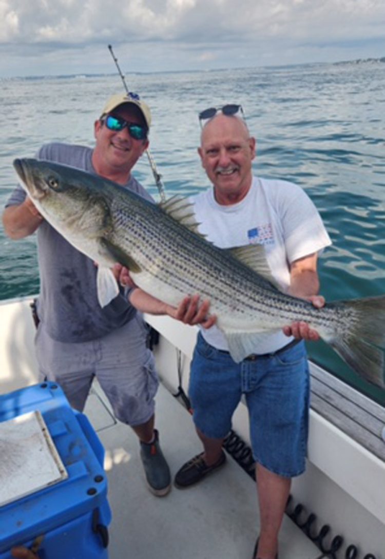 Joe Holey and his new friend with striped bass