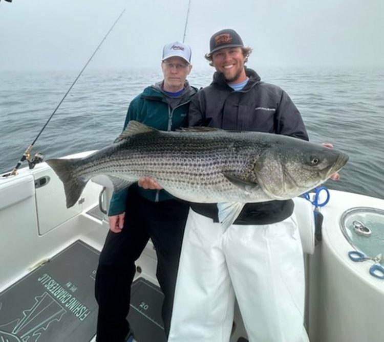 Captain Peter Aikens and charter Anthony Cassarino with big striped bass