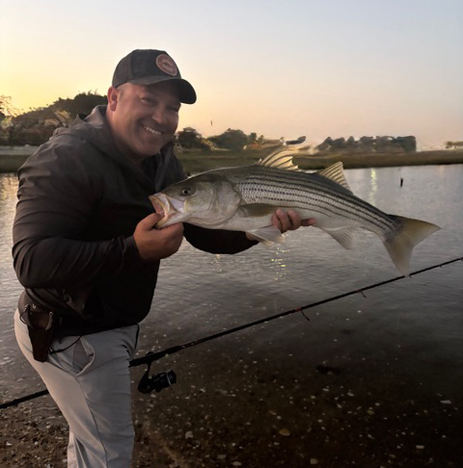 Captain Lou Tirado of Diamond Pass Charters with backwater striped bass