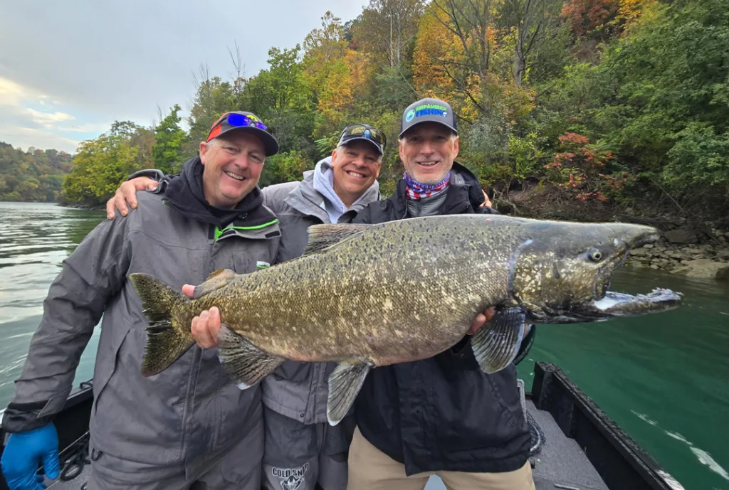Glenn Hughes president of ASA holding salmon, Joe Henry incoming president for AGLOW in center, and Capt. Frank Campbell