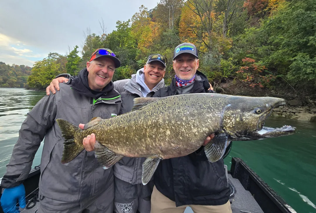 Glenn Hughes president of ASA holding salmon, Joe Henry incoming president for AGLOW in center, and Capt. Frank Campbell